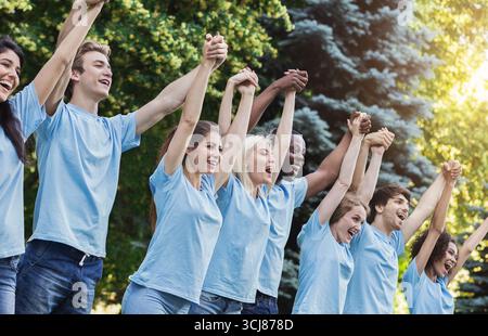 Melden Sie Gruppe von jungen Freiwilligen Hände in Park Stockfoto