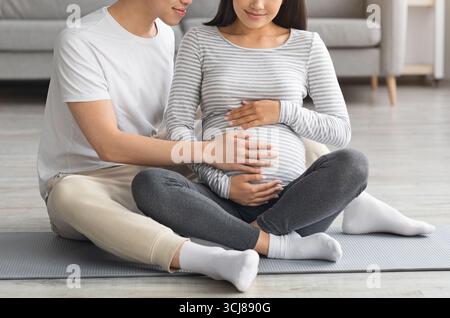 Eine junge, erwartete Familie, die gemeinsam den Fitnesskurs genießen kann Stockfoto