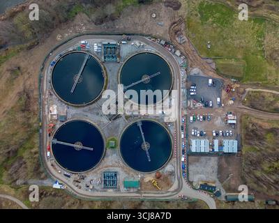 Übersicht über eine Abwasseraufbereitungsanlage mit Rundtanks und umliegenden Infrastrukturen Stockfoto