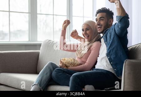 Emotionale arabische Paar Fußballfans beobachten Spiel Stockfoto