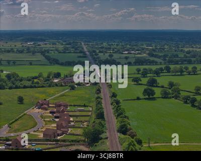 Weitläufige Landschaft mit Eisenbahn- und Wohngebiet unter einem klaren blauen Himmel Stockfoto