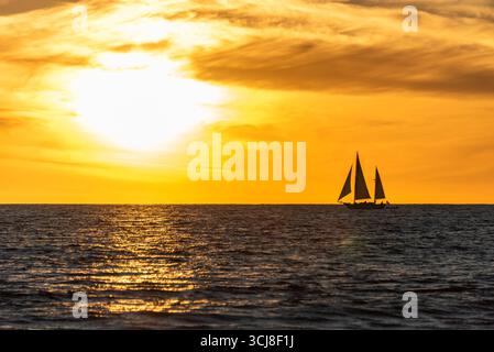 SANTA MONICA, KALIFORNIEN, USA: Ein Segelboot wird von einer Wintersonne über dem Pazifik in der Nähe des Santa Monica Pier in Santa Monica, Kalifornien, beleuchtet. Stockfoto
