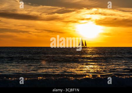 SANTA MONICA, KALIFORNIEN, USA: Ein Segelboot wird von einer Wintersonne über dem Pazifik in der Nähe des Santa Monica Pier in Santa Monica, Kalifornien, beleuchtet. Stockfoto