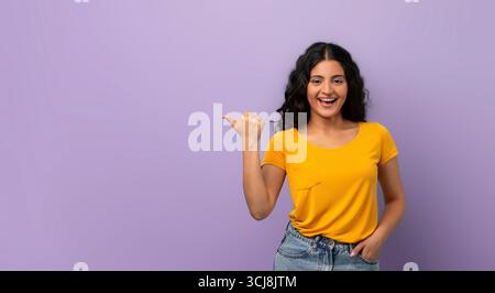 Fröhliche junge indianerin, die auf den Kopierraum zeigt Stockfoto