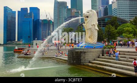 Die legendäre Merlion-Statue, die Wasser in der Marina Bay in Singapur mit der modernen Skyline im Hintergrund spuckt. Stockfoto