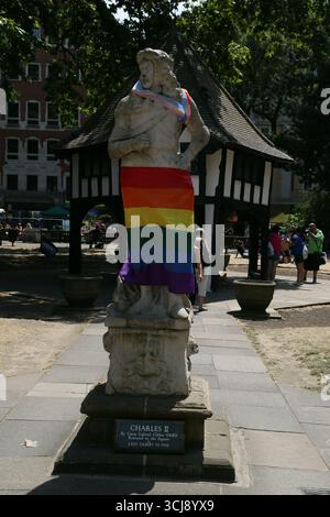 Der Soho Square, der die Steinstatue von König Karl II., die während der Pride in London 2018 in zwei Stolz-Flaggen gehüllt wurde, schmeichelt Stockfoto