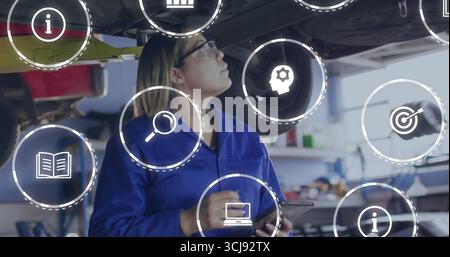 Techniker inspiziert den Flugbauch im Hangar mit Brille mit einem Tablet mit schwebenden Symbolen Stockfoto