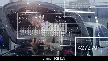 Er hält einen Techniker, der Blazer trägt, und analysiert Overlays auf dem Tablet in der Wartungshalle neben dem Fließheck-Auto Stockfoto