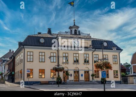 Rathaus der Gemeinde Västervik in Schweden mit rund um die Uhr und Flagge Stockfoto