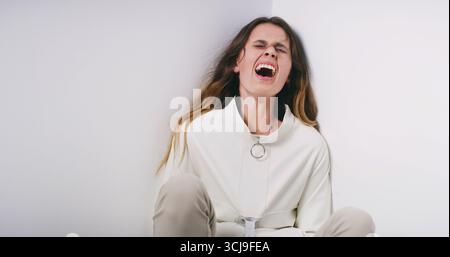 Frau, schreiende und psychiatrische Klinik mit Zwangsjacke wegen Schizophrenie in psychiatrischer Einrichtung. Weibliche Person, bipolar oder schreiend mit Angst Stockfoto