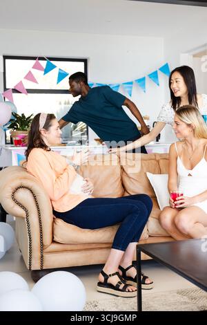 Freunde genießen lebhafte Indoor-Party mit farbenfroher Dekoration und Lachen Stockfoto