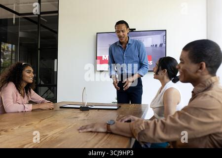 Geschäftstreffen mit verschiedenen Teams, bei denen das Projekt am Konferenztisch diskutiert wird Stockfoto