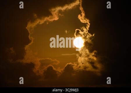 Die Sonne hinter einem Fenster aus dicken Cumulus-Wolken Stockfoto