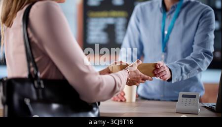 Eine Geschäftige Geschäftsfrau Bestellt Espresso Am Morgen Bei Einem Lokalen Coffee Shop-Besitzer Stockfoto