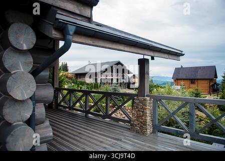 Rustikale Holzhütten in einer bergigen Landschaft mit bewölktem Himmel. Stockfoto