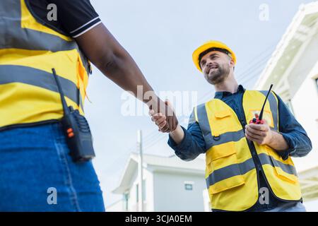 Das Team des Bauarbeiters schüttelt die Hand, die Begrüßung durch Ingenieure starten neues Projekt, der Geschäftsvertrag auf der Baustelle, die Partnerschaft und der Vertrag mit Auftragnehmern h Stockfoto