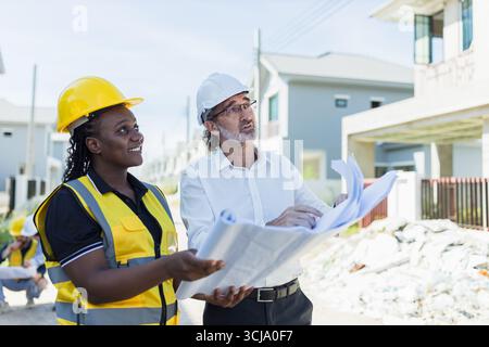 Leitender Bauingenieur Projektmanager Arbeiten Inspektion des Hausbauprojekts mit Bauunternehmerinnen und Hausdesign-Grundriss Stockfoto
