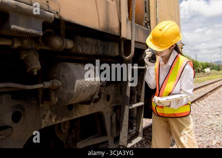 Asiatischer junger Teenager-Ingenieur arbeitet im Bahnhof, alte Lokomotivwartungsarbeiten Motor unter Pkw-Lokomotivkontrolle Wartung Stockfoto