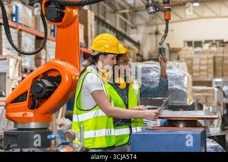 Roboteringenieurausbildung, Techniker arbeiten in der modernen Fabrik industrielle Roboter Schweißarm Maschinenbediener Stockfoto