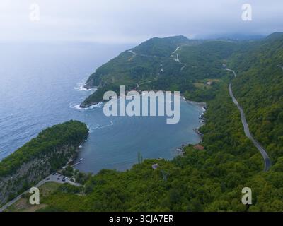 Aus der Vogelperspektive auf eine ruhige Küste mit bewaldeten Bergen und einer gewundenen Straße, aus der Vogelperspektive, Gideros GuendoGdu Bay, Guendogdu, Cide, Provinz Kastamonu, B. Stockfoto