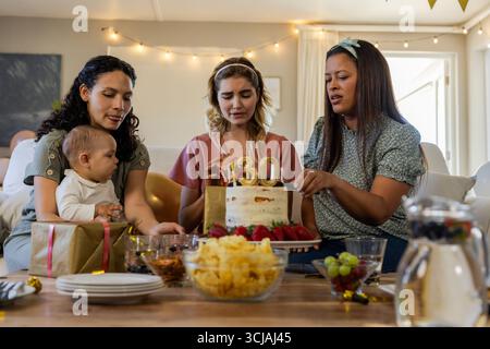 Geburtstagsfeier, vielfältige Frauen und Babys genießen Kuchen und Geschenke zu Hause Stockfoto