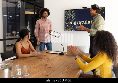 Feiern Sie den Erfolg, sprechen Sie im Büro ein Team aus, um die Leistung des Kollegen zu würdigen, lächeln Sie Stockfoto