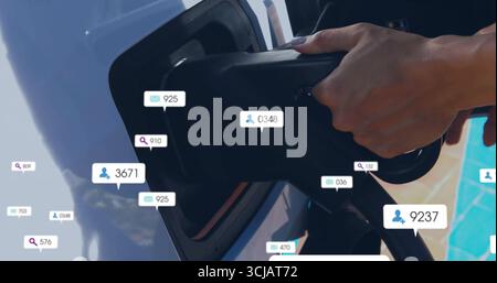 Hand zum Einstecken des EV-Steckverbinders in den Anschluss der EV-Station, mit Symbolen für soziale Kennzahlen, Kopierraum Stockfoto