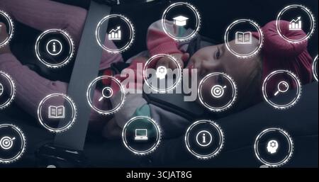 Sitzendes Kleinkind mit rosafarbenem Hut Fäustlinge graue Jacke im Auto, mit Sitzgeschirr, digitale Symbole Stockfoto