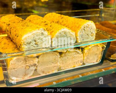 Türkische Delikatesse gefüllt mit Sahne und Nüssen in einem Süßwarengeschäft. Süße, Tradition und Gourmet-Genuss durch Dessert Stockfoto