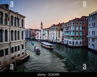 Eine ruhige Dämmerungsszene auf dem Canal Grande in Venedig, Italien. Das Bild fängt die berühmte Wasserstraße ein, während ein Wasserbus (Vaporetto) vorbei an Pracht fährt Stockfoto