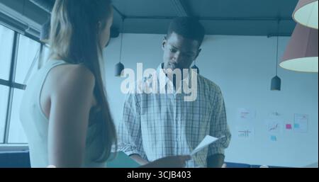 Bürokollegen prüfen Dokumente und diskutieren in der Lounge, mit Wandtafeln und Hängelampen Stockfoto