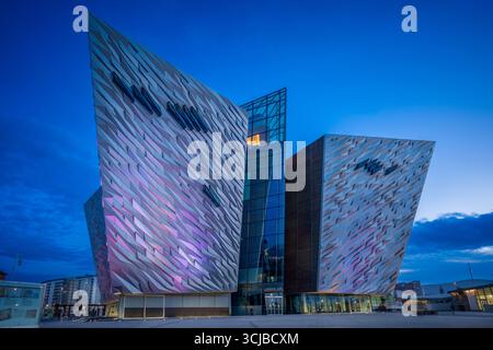 Abendblick auf das Titanic Belfast Museum, beleuchtet während der blauen Stunde, mit moderner Architektur, die das maritime Erbe der Stadt widerspiegelt. Stockfoto