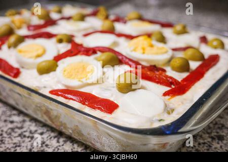 Traditionelle spanische Ensaladilla Rusa mit gekochten Eiern, Paprika und Oliven Stockfoto