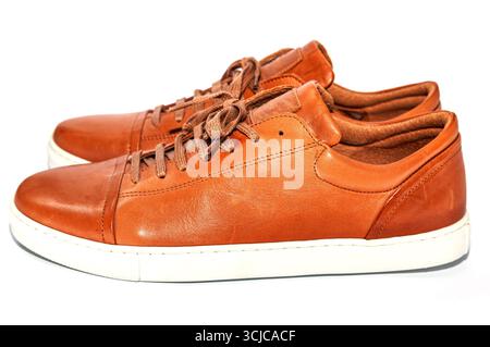 Herren Jugendschuhe aus Leder in brauner Farbe mit weißer Sohle auf weißem Hintergrund. Stockfoto
