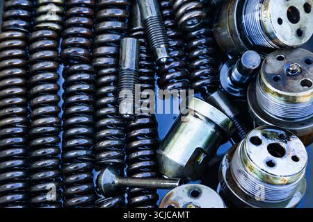 Mechanische Stahlteile mit Maschinenöl geschmiert, Nahaufnahme. Stahleinspritzdüsen, Federn, Buchsen, Bolzen und Gewindeteile in Öl. Stockfoto