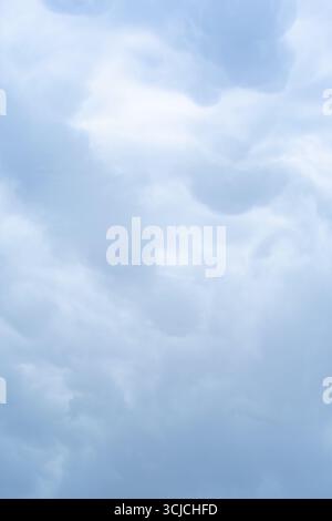 Ein ätherischer Blick auf den Himmel mit abstrakten Wolkenformationen in sanften Grautönen. Das flauschige, bewölkte Erscheinungsbild schafft ein ruhiges und ruhiges Ambiente Stockfoto