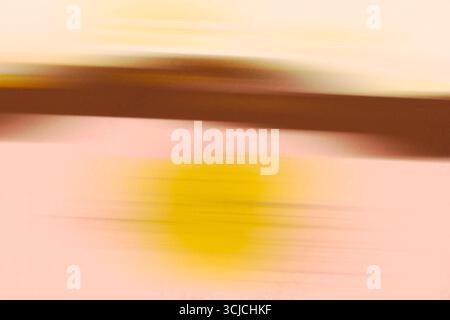 Abstraktes Bild mit Bewegungsunschärfe in sanften Rosa-, Braun- und Gelbtönen. Die Farben verschmelzen nahtlos und schaffen eine traumhafte und energiegeladene Atmosphäre Stockfoto