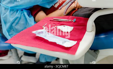 Ein detaillierter Aufbau von Instrumenten, die in der Zahnimplantologie verwendet werden, auf einem Zahnstuhl für einen chirurgischen Eingriff platziert werden, um die akribische Natu hervorzuheben Stockfoto