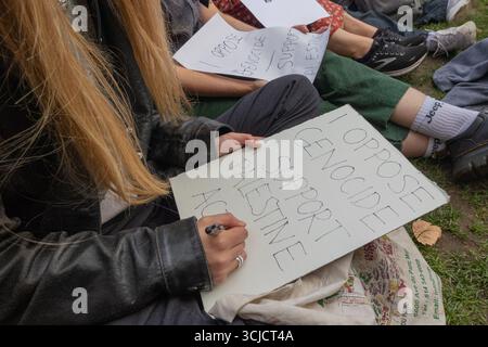 London, Großbritannien. September 2025. Eine Gruppe von Aktivisten sitzt auf dem Gras und bereitet Protestzeichen vor, einschließlich einer Lesung, in der ich GEGEN DIE AKTION ZUR UNTERSTÜTZUNG DES VÖLKERMORDS IN PALÄSTINA bin. Die Szene fängt den politischen Ausdruck der Basis und die Solidarität mit Palästina im Vereinigten Königreich ein. Verteidigen Sie unsere Geschworenen gegen das Verbot der Palästinensischen Aktion, indem über 1000 Menschen sich verpflichten, Zeichen zu halten, die gegen das Verbot von Labour verstoßen, und zeigen Unterstützung für die verbotene Gruppe. Penelope Barritt/Alamy Live News Stockfoto