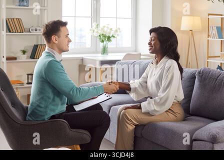 Glückliche Patientin, die mit ihrem Psychotherapeuten oder einer Psychologin die Hand schüttelt Stockfoto