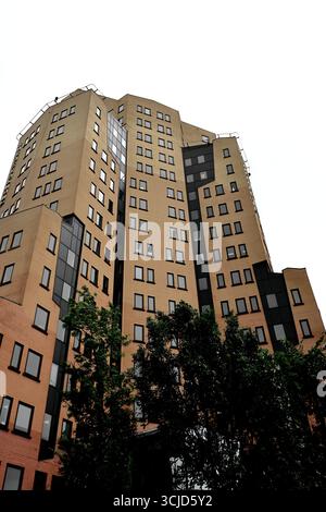 Blick nach oben auf Regus Büros in Teleport Towers, Sloterdijk, Amsterdam, Niederlande, mit braunen und roten Ziegeln, dunklen Einsätzen und Reihen von quadratischen Fenstern. Stockfoto