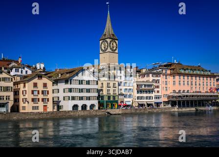 Ikonische Peterskirche mit der größten Kirchuhr Europas und historischen Gebäuden an der Limmat in der Altstadt, Zürich, Schweiz Stockfoto