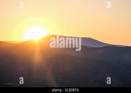 pamukkale, Turkiye, 08.07.2025 Goldener Sonnenaufgang oder Sonnenuntergang über einer Bergkette in der Türkei, die die Landschaft beleuchtet. Natürliche Schönheit und Reisekonzept Stockfoto