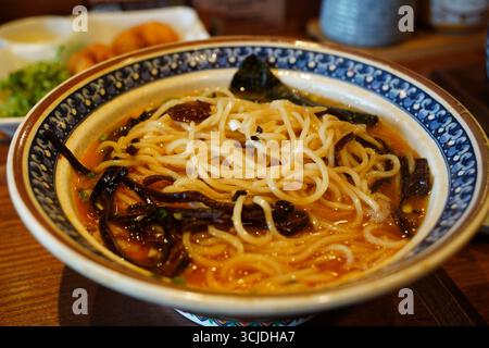 Köstliche Schüssel Ramen-Nudeln mit Algen und Pilzen Stockfoto