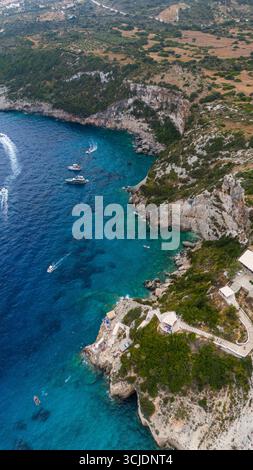 Zakynthos Griechenland Blue Caves Area mit Blick von oben auf felsige Klippen, grüne Vegetation, Ionisches Meer und Windmühle Wahrzeichen in der Nähe traditioneller Häuser auf dem Hügel Stockfoto