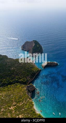 Agios Andreas Höhleninsel aus der Vogelperspektive mit dramatischen felsigen Klippen, türkisfarbener Bucht, tiefblauem Ionischen Meer und üppigen grünen Hügeln entlang der Küste Stockfoto