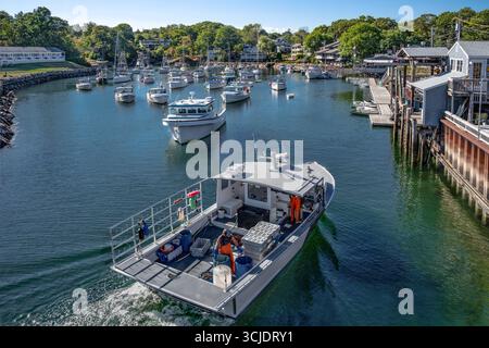 Hummerboot zurück zum Dock: Ein kommerzielles Fischerboot mit Hummer-Boxen fährt in einen kleinen Hafen in der Nähe von Ogunquit, Maine. Stockfoto