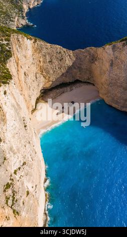 Blick aus der Vogelperspektive auf Shipwreck Beach Zakynthos Griechenland mit hellem türkisfarbenem Wasser abgeschiedener Sandbucht und einem alten Schiffswrack, das von Kalksteinklippen eingerahmt wird Stockfoto