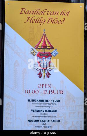 Schild für die Basilika des Heiligen Blutes, in der ein Relikt des Heiligen Blutes Christi mit Angaben zu Öffnungszeiten und Gottesdiensten am 17. Juli in Brügge, Belgien Stockfoto