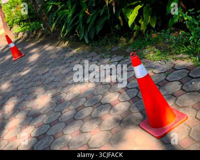 Zwei Kegelschilder stehen auf dem Betonpflaster als Begrenzungsmarkierungen Stockfoto
